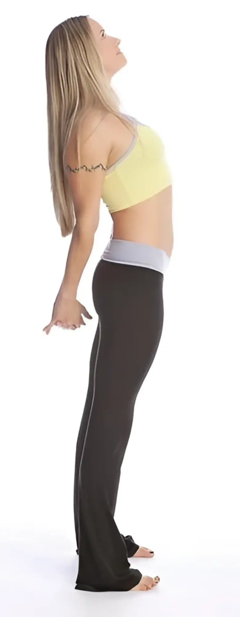 A woman wearing 4-rth women’s classic yoga pant in black with white side stripes and a yellow sports bra with gray trim