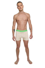 Cream-colored boxer briefs with bright green elastic waistband and brand logo shown from the front