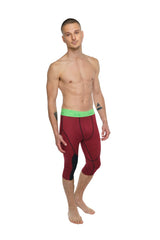 Performance yoga leggings 3/4 in brick red heather with bright green waistband and black panel accents for activewear