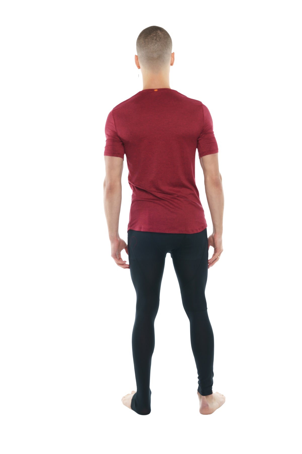 A man wearing a brick red heather perfect pocket crew-neck tee with maroon short sleeves and black leggings