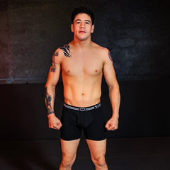 Black briefs with a white striped waistband featuring the she logo from the sheath 4.0 best-seller dual pouch boxer briefs 3-pack