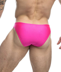 Bright pink sleek form-fitting swim trunks from justin simon classic mens bikini collection for swimming and beachwear