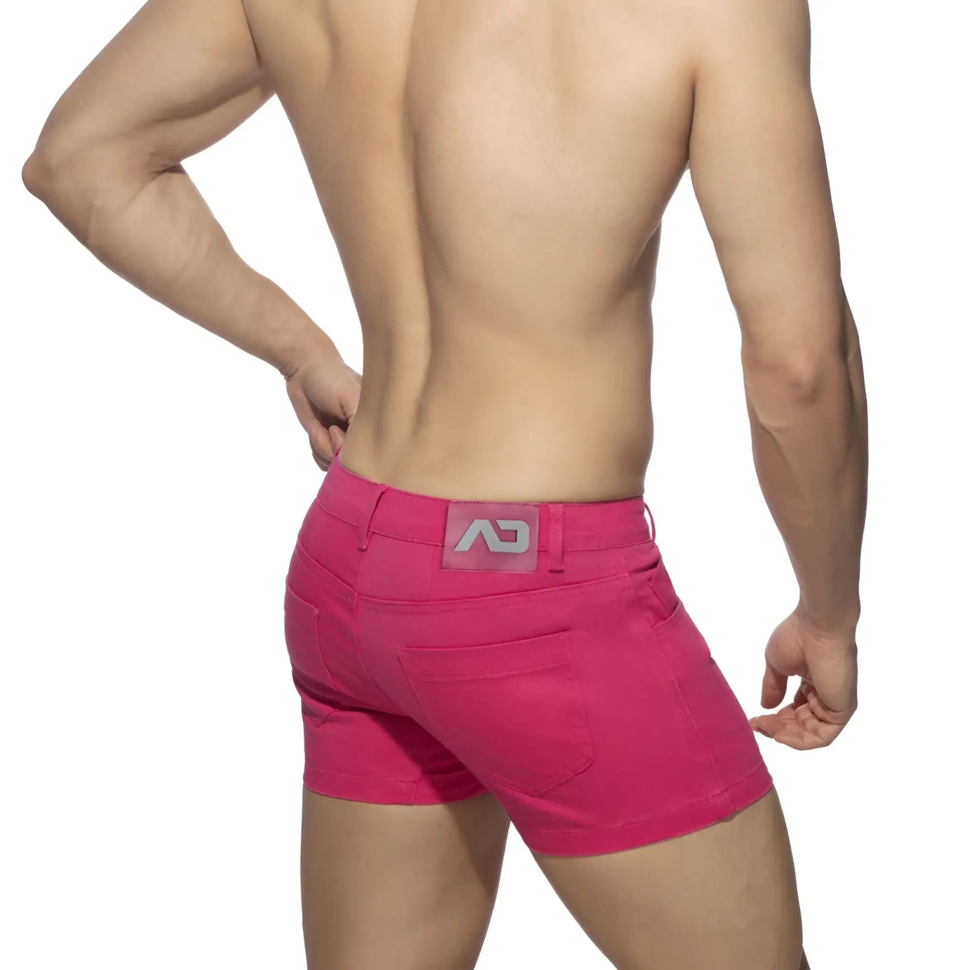 Bright pink 5 pockets summer shorts showing the back side with a gray logo patch on the waistband