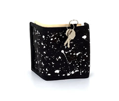 Black 80s velcro wallet with white paint splatter design and attached key ring with keys at the top