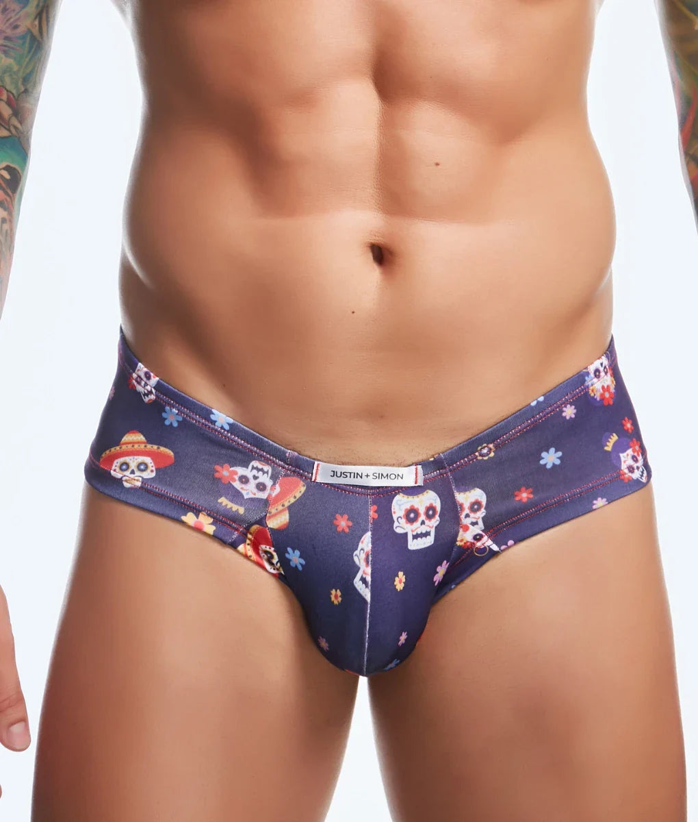 Dark blue men’s briefs with vibrant sugar skulls wearing sombreros and floral accents branded justin simon