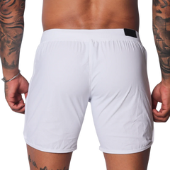 Plain white athletic shorts with a smooth, lightweight fabric, elastic waistband, and small black logo tab on the back.