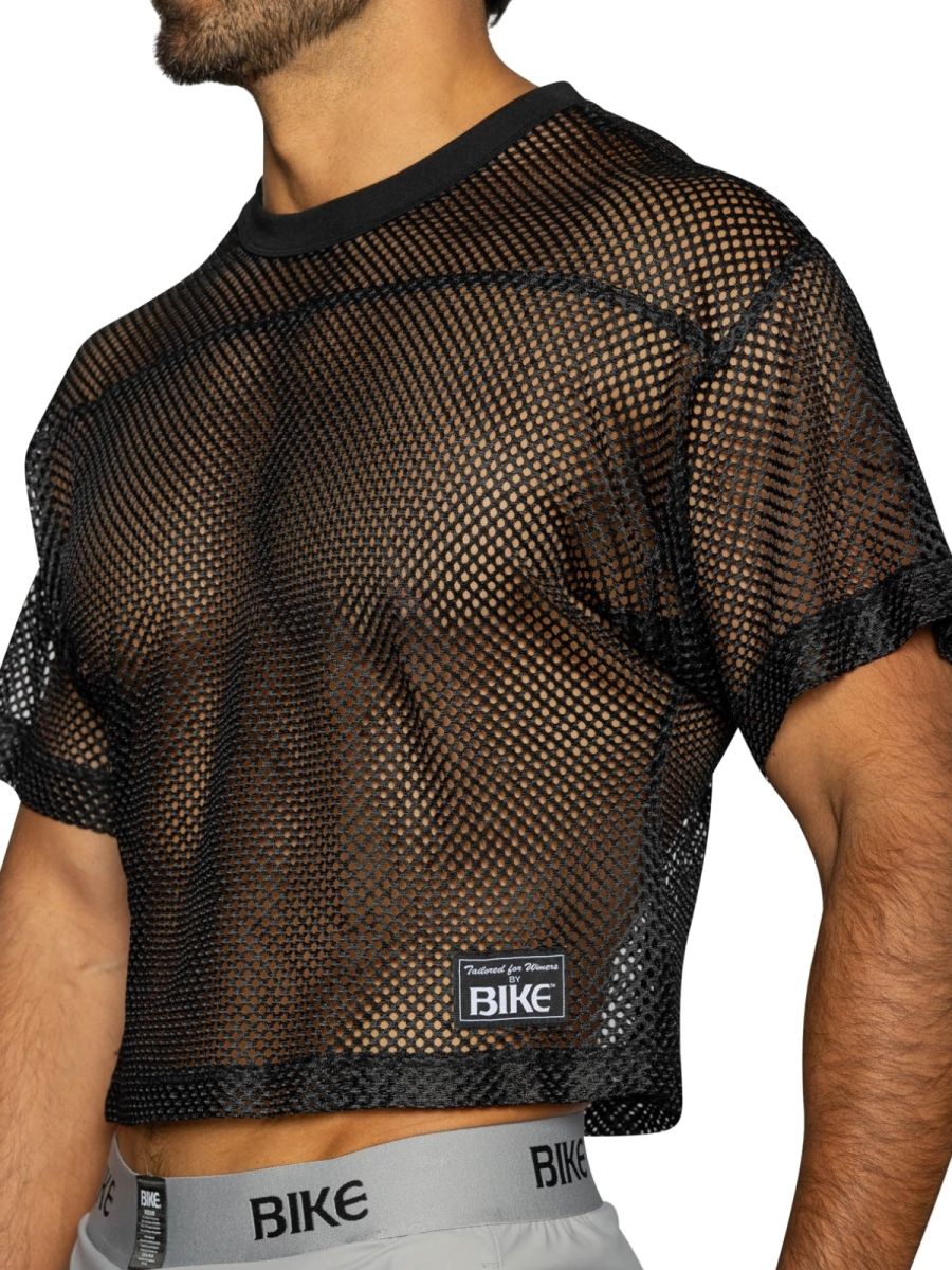 Black mesh crop top with solid ribbed neckline and cuffs featuring small rectangular bike brand label on front
