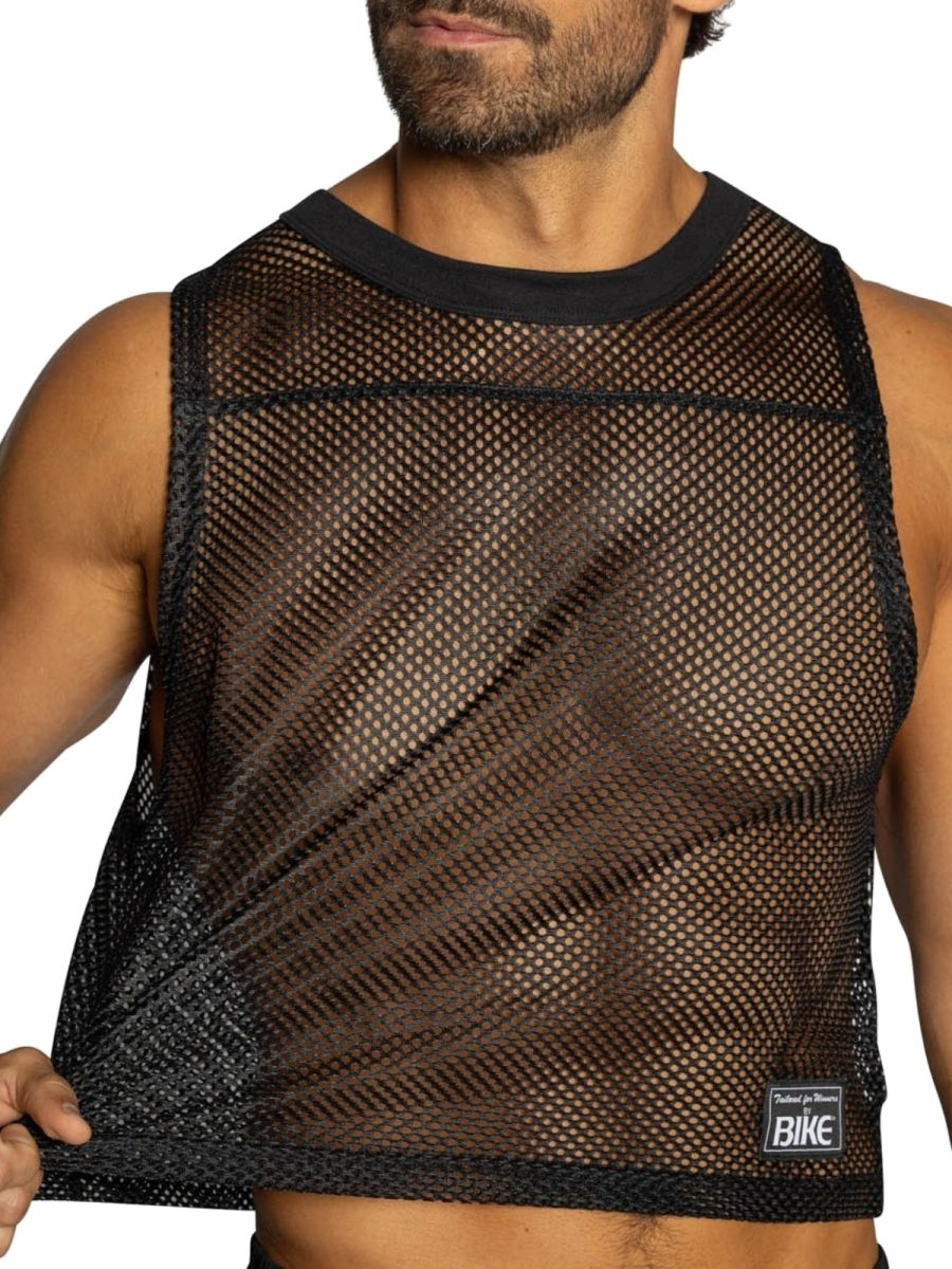Black mesh crop top with solid black ribbed neckline and hem featuring small rectangular label on lower right side