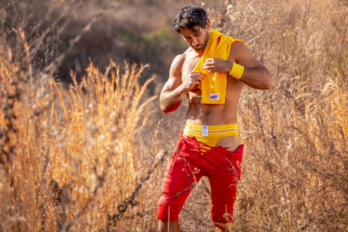Man wearing a yellow BIKE athletic jockstrap with a small white logo in an outdoor setting