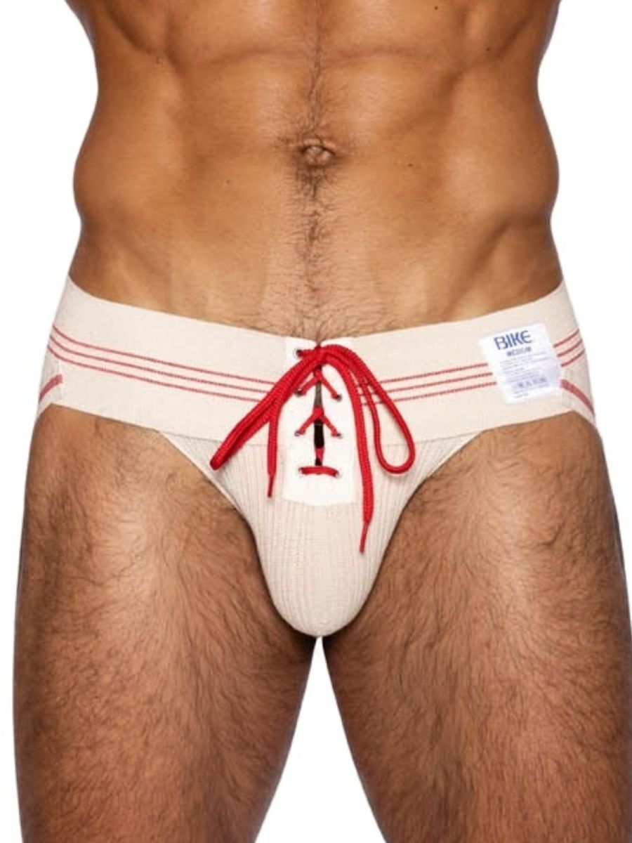Cream-colored ribbed men’s briefs with red lace-up detailing and matching stripes on the waistband by BIKE Athletic