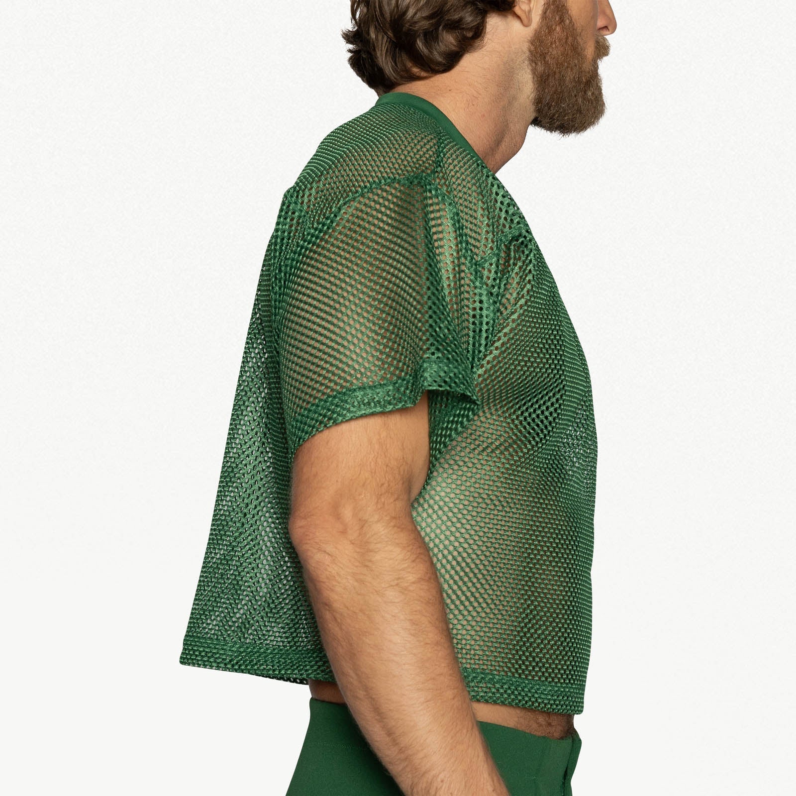 Side profile of a man wearing a green BIKE Athletic mesh practice jersey against a plain background.