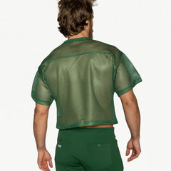A man from behind wears a green mesh practice jersey and matching green pants.