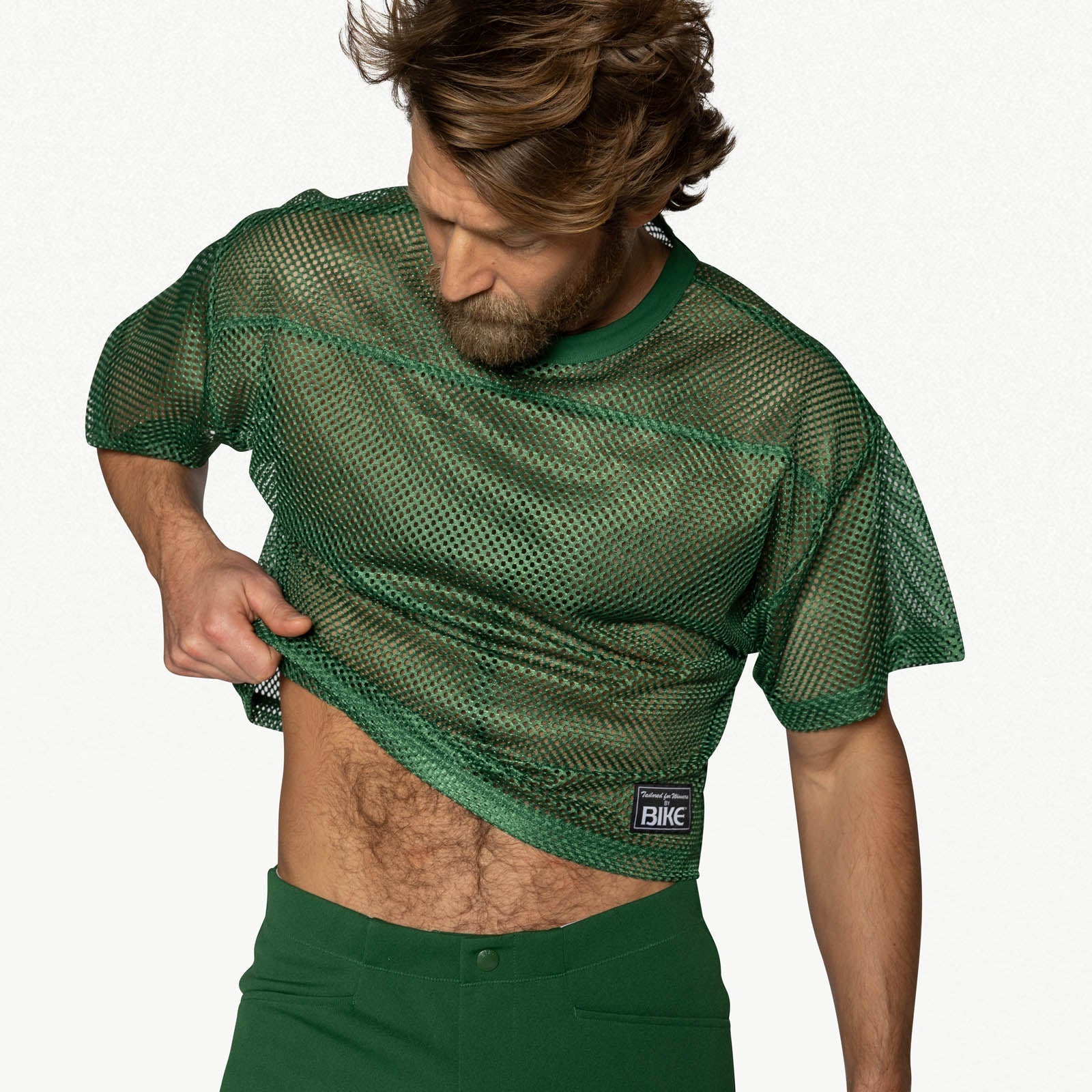 Bearded man wearing a green mesh BIKE practice jersey with short sleeves and a small patch logo on the hem.