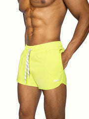 Bright neon yellow bike track short with white striped drawstring and subtle brand logo on lower right leg