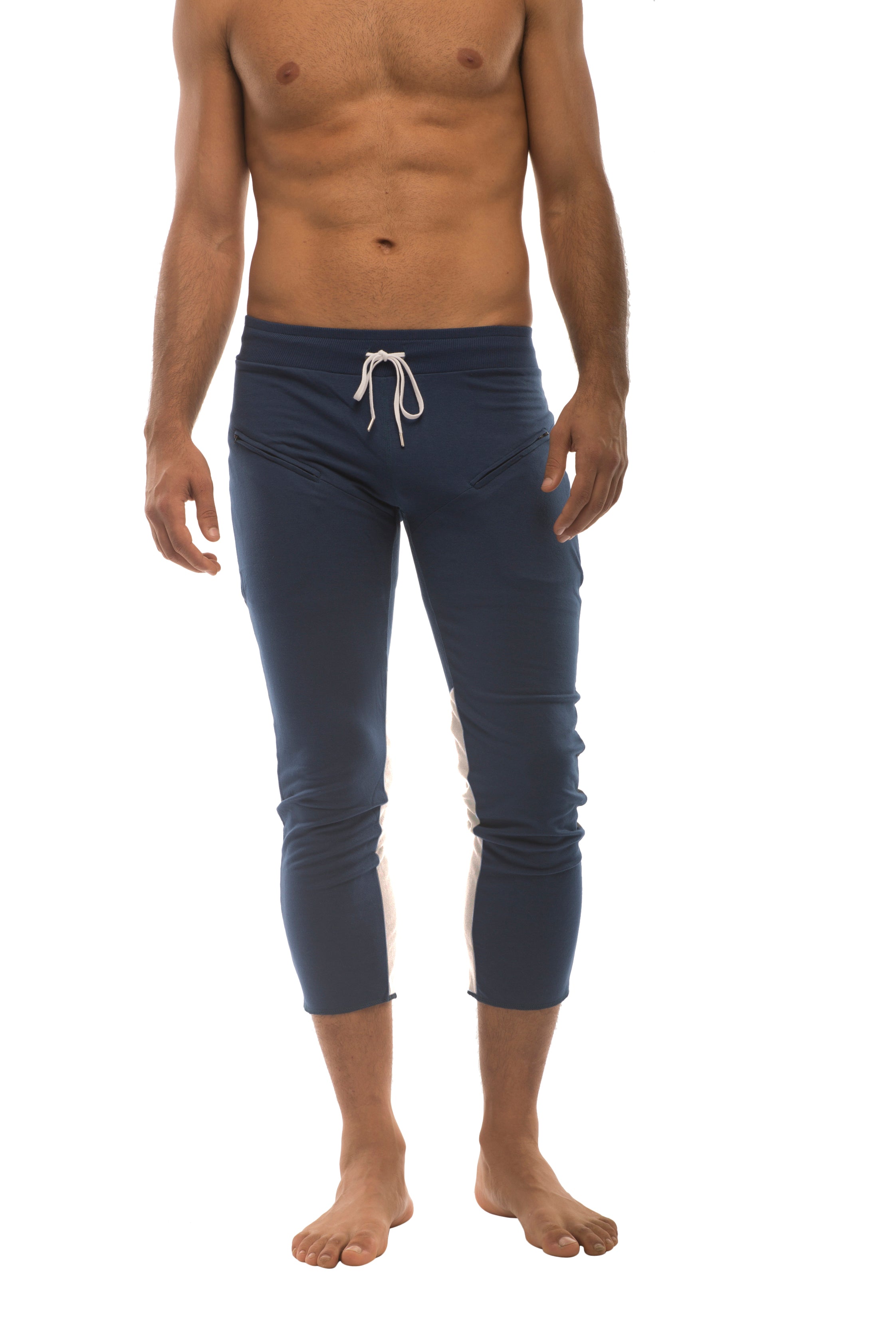 Mens navy blue athletic capri yoga pants with white drawstring and side stripes featuring 4/5 zipper pockets