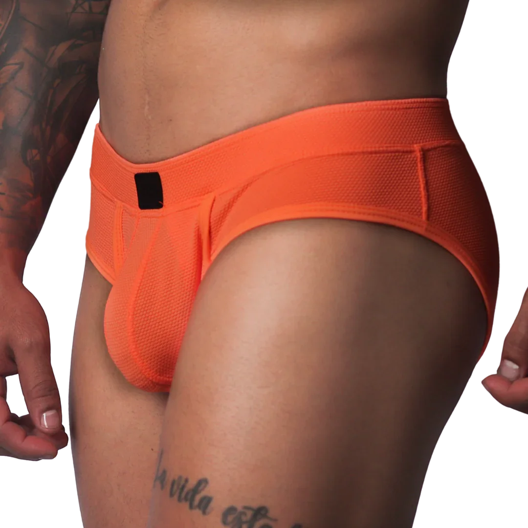 Bright orange textured mesh athletic brief with a wide waistband and a small black rectangular logo patch in front.