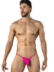 Male model wearing bright pink lace thong with thin straps by CandyMan against white background