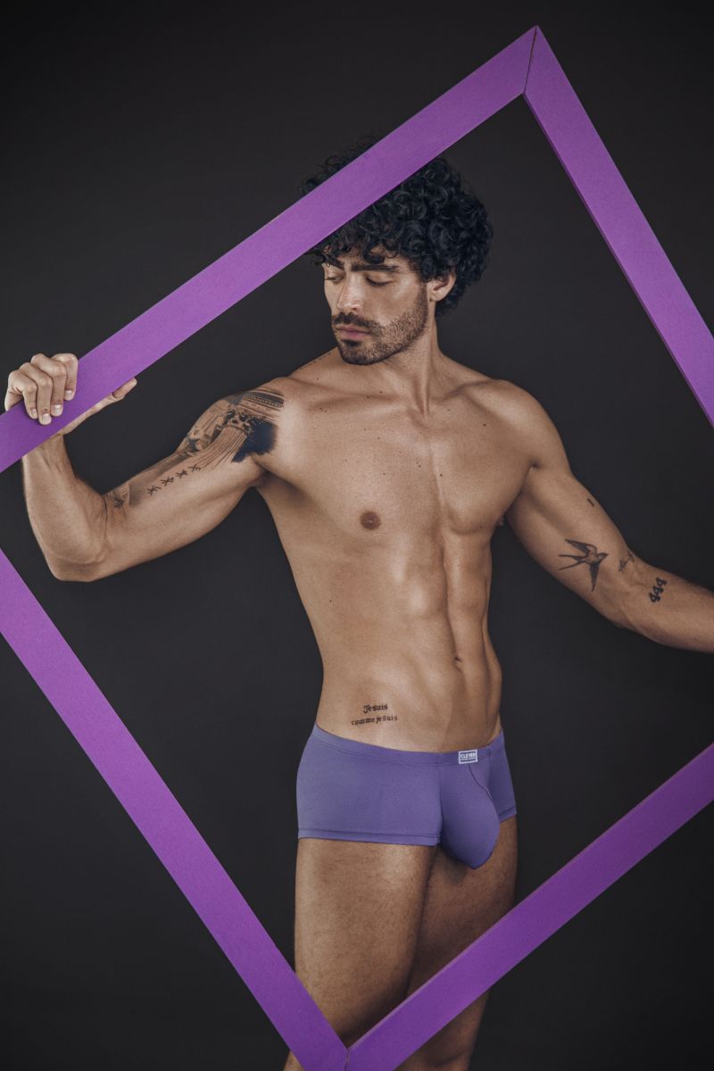 Clever Moda lilac Cronos trunks worn by a tattooed man posing inside a purple frame.
