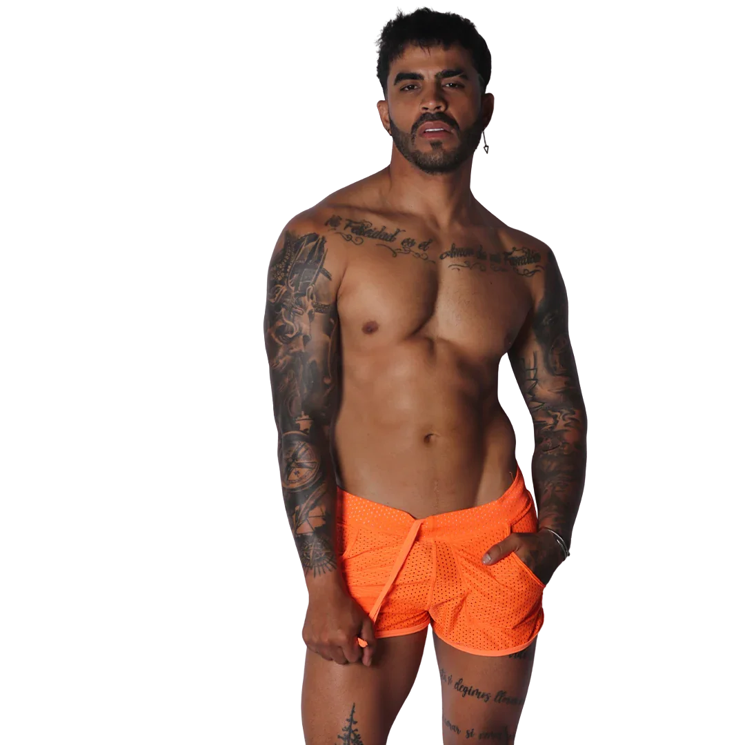Neon orange mesh athletic shorts with a drawstring waist, modeled by a tattooed man against a black background.