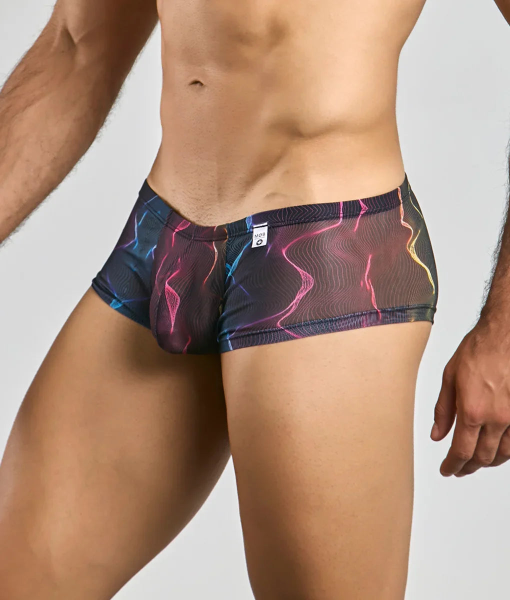 MOB men’s sexy sheer hip brief in electric pink blue and yellow lightning-patterned mesh against dark base