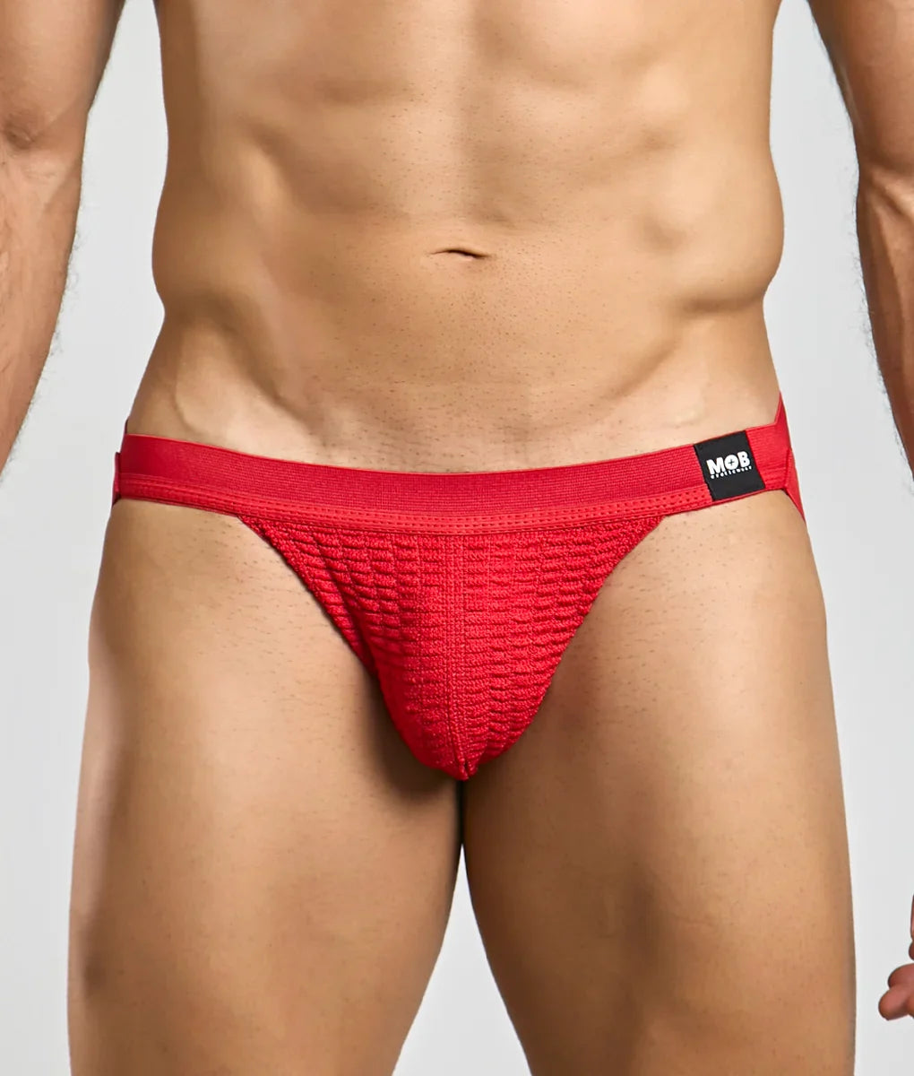 Red textured briefs with a black mob brand tag on the waistband from the mob swim jockstrap collection
