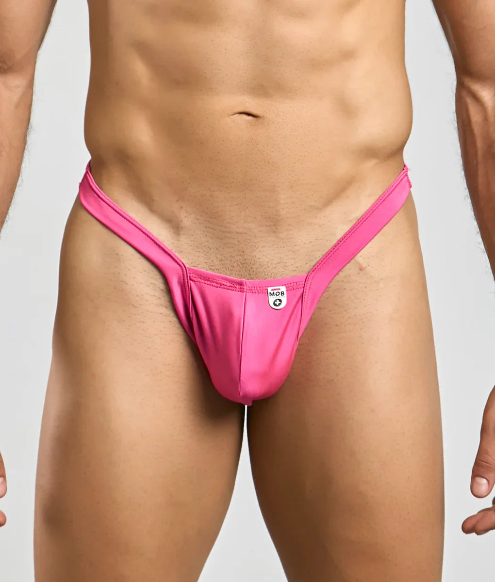 Bright pink sleek form-fitting thong made from smooth stretch fabric with small white mob y buns brand tag at center