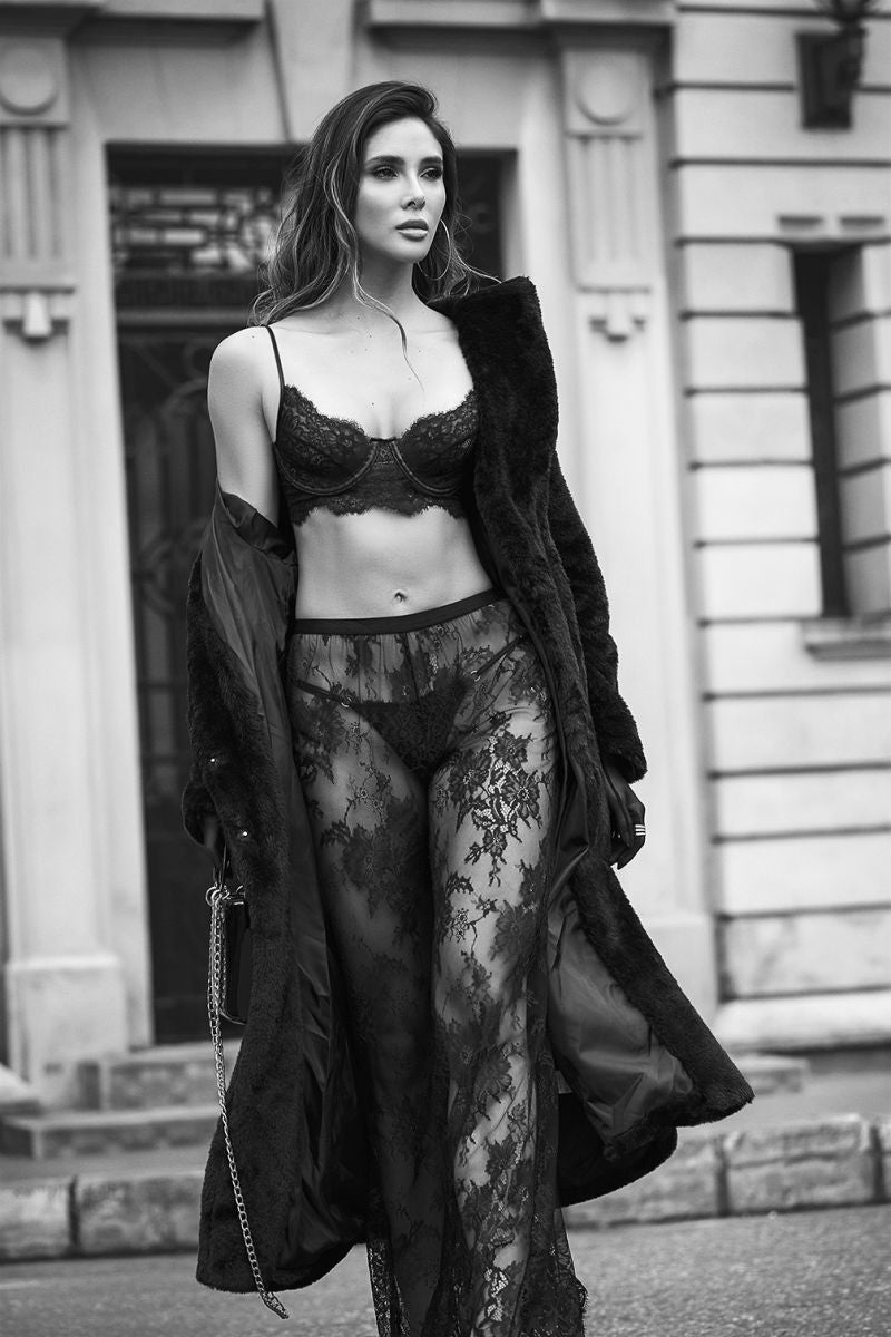 Black three-piece lingerie set worn with a faux fur coat outdoors.