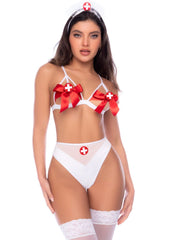 Model wearing white nurse costume with red bows, cross appliques, high-waisted briefs, and matching stockings.