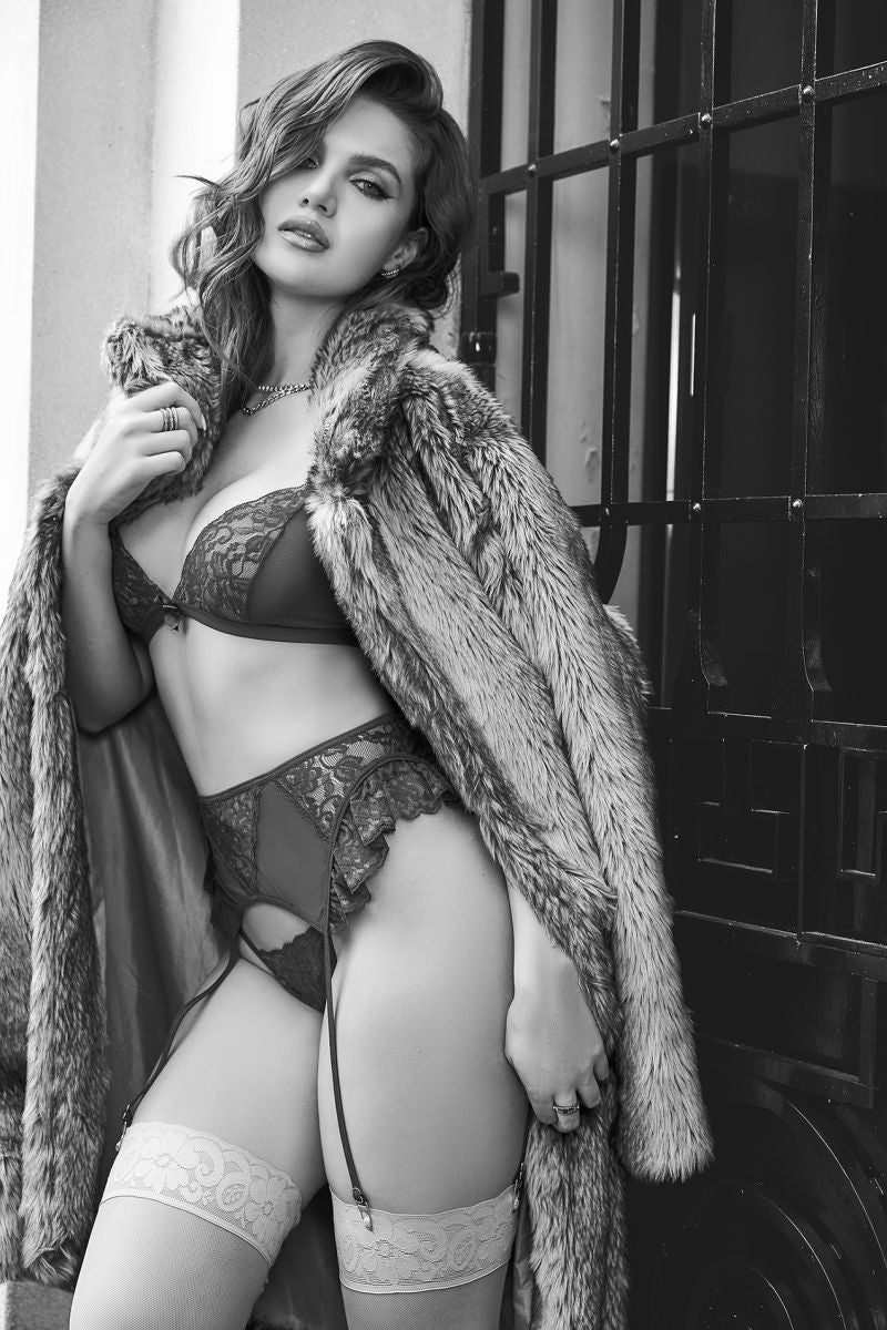 A three-piece lingerie set worn under a fur coat, featuring a lace bra, garter belt, and stockings.