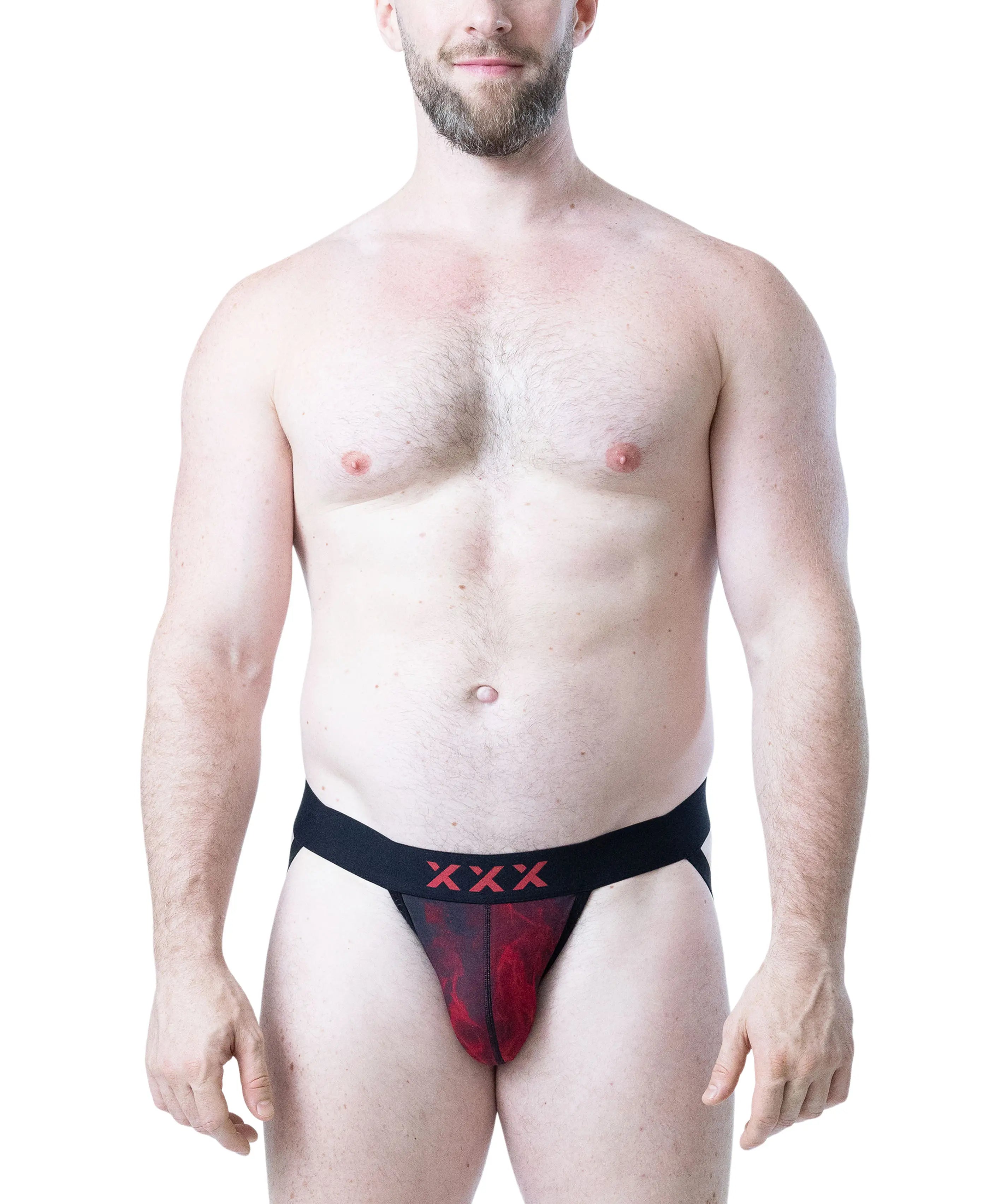 Male model wearing black and red flame-patterned jockstrap with XXX detail on waistband by Nasty Pig