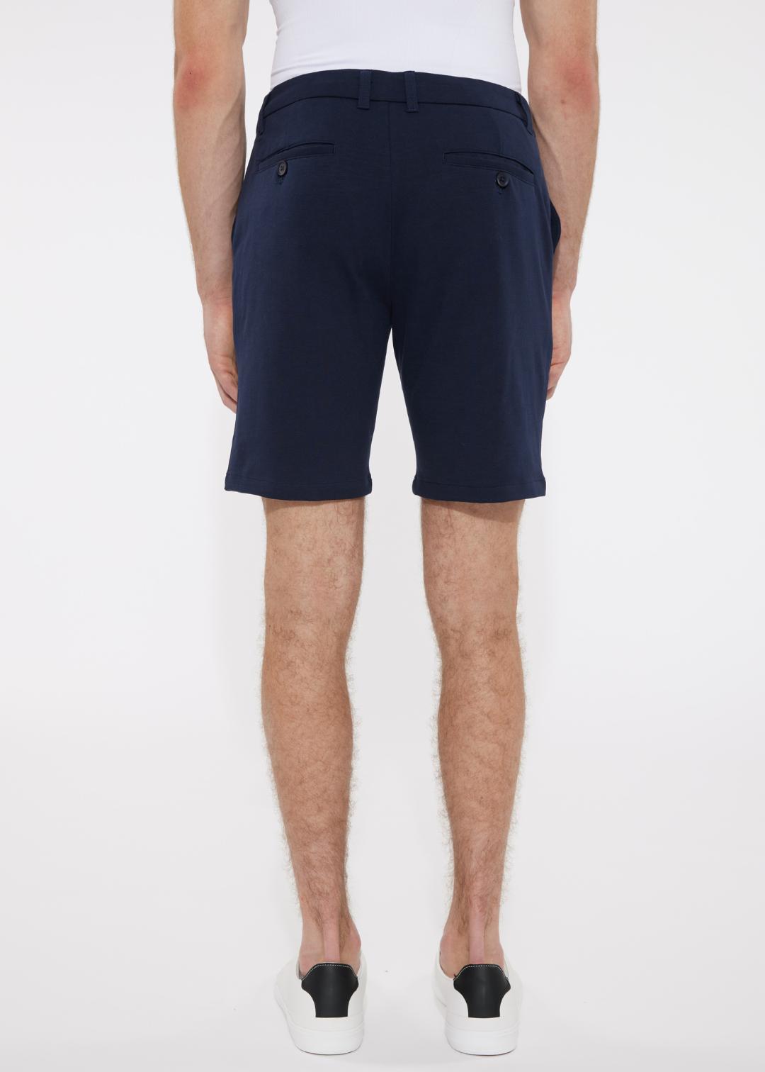 Navy blue solid stretch knit shorts with buttoned back pockets shown from the back in a tailored modern cut