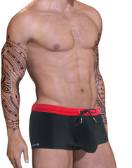 Black square-cut swim trunks with a prominent pouch, red waistband, and adjustable black drawstring.