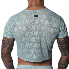 Aqua floral lace crop top with short sleeves and a small black brand tag at the back neckline.