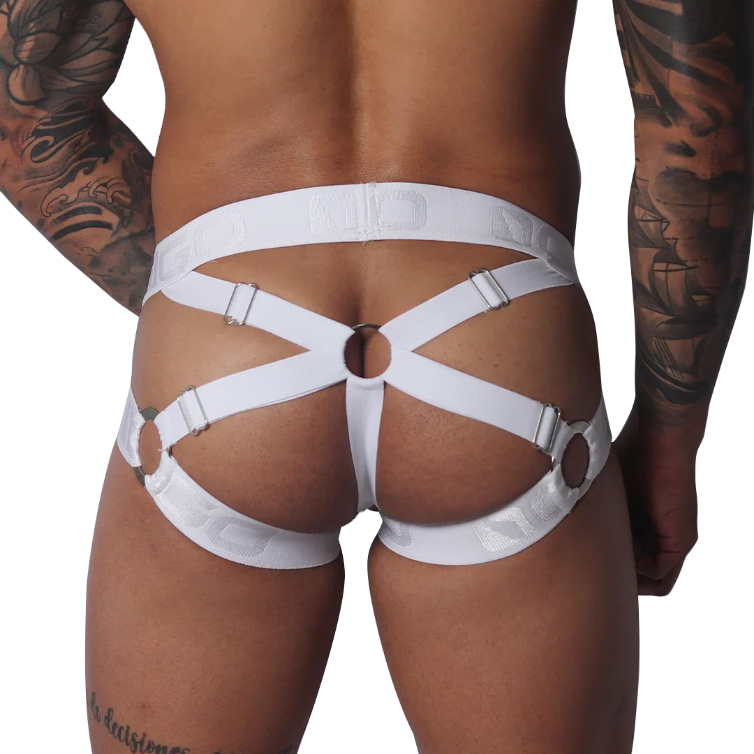 White jockstrap with elastic straps, silver metal rings, and adjustable sliders on a tattooed male model.