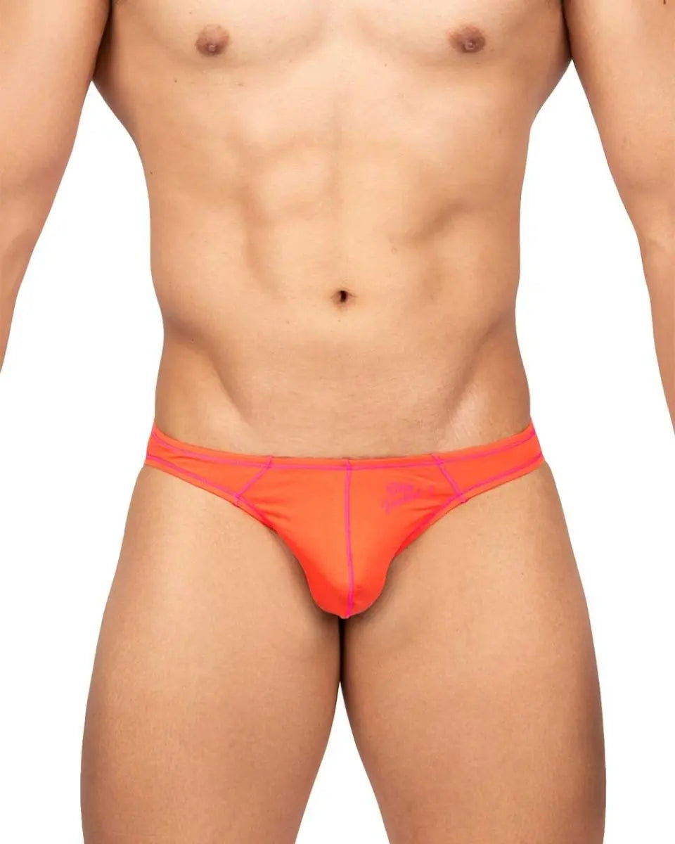 Front view of a male model wearing bright orange bikini brief with contrast stitching and logo on left side by Private Structure