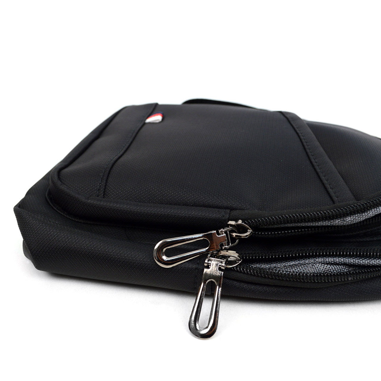 Black nylon crossbody sling bag with silver zipper pulls and small red white and blue logo on front