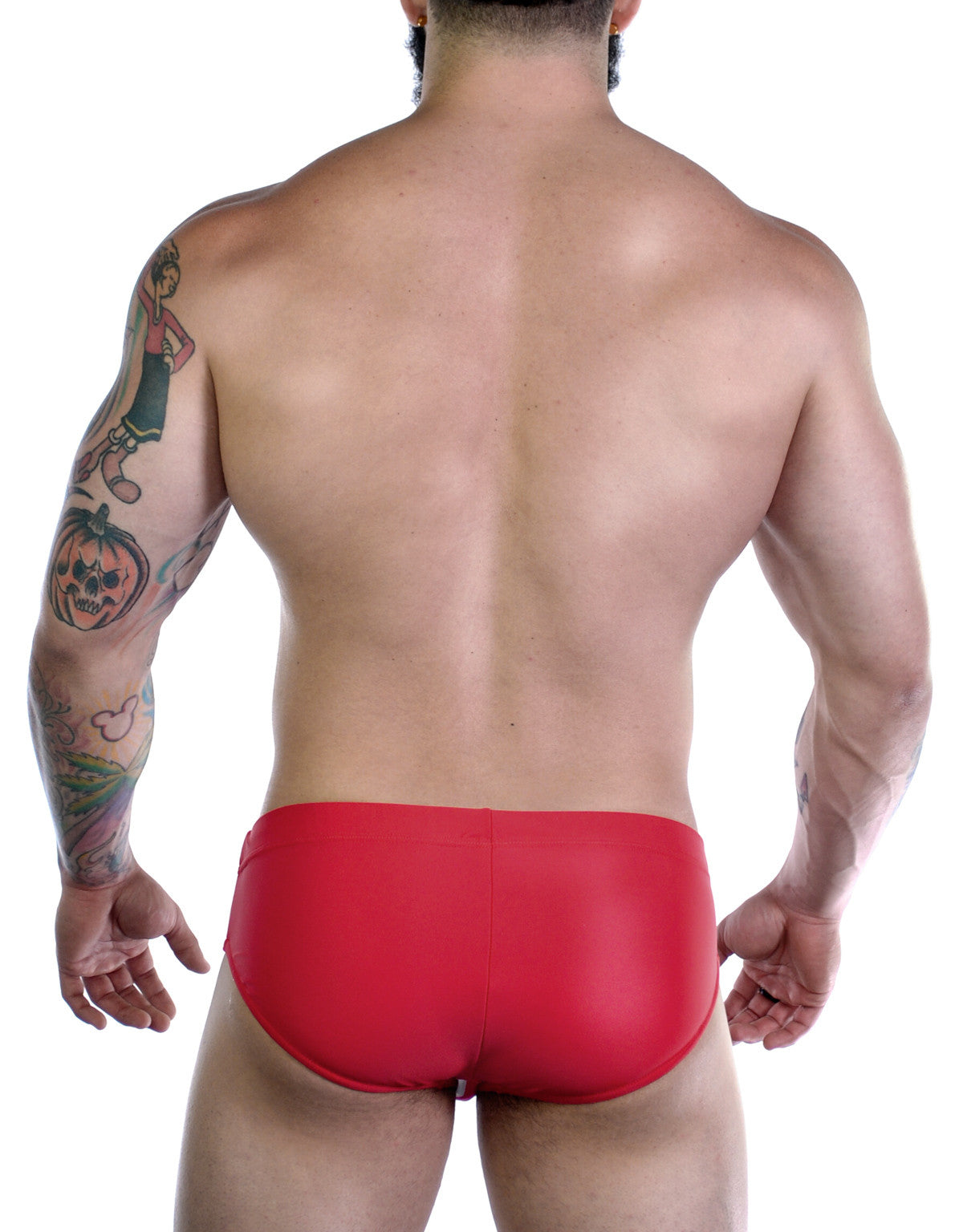 Back view of a muscular man wearing red Sportivo bikini swimwear with visible arm tattoos against a white background.