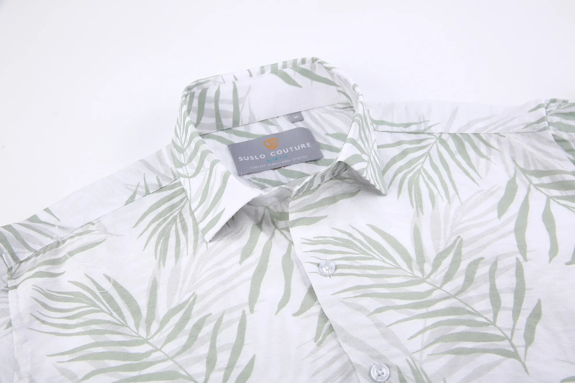 White button-down summer rain s/s shirt with subtle green palm leaf pattern and suslo couture label at the collar