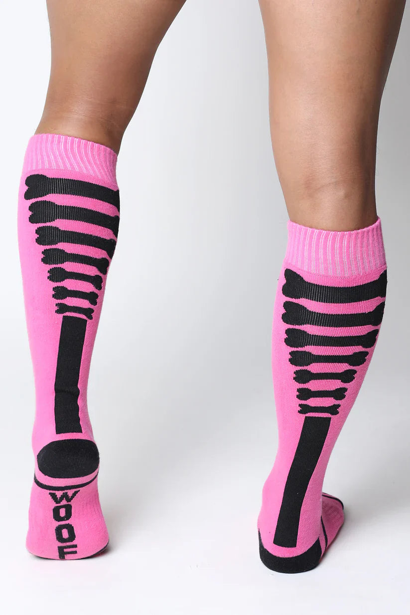 Pink kennel club bones knee high wool socks with black skeletal bone pattern and wool printed on the heel