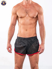 Men's black sprint shorts with red trim featuring an elastic waistband shown on a model by AMERICAN JOCK.