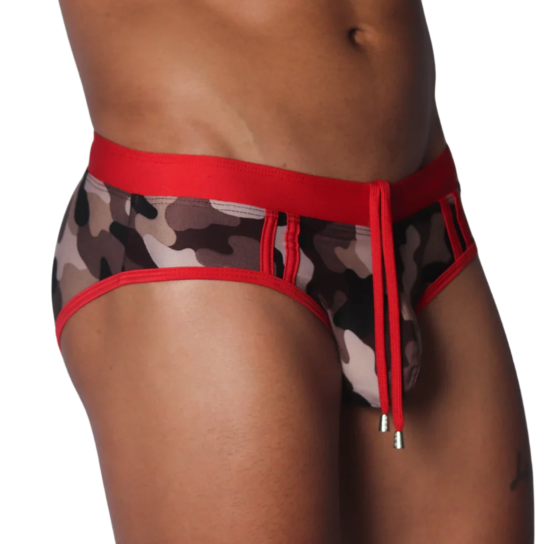 Sheer camo print swim brief with a red elastic waistband, matching trim, and front drawstring with metallic toggles.