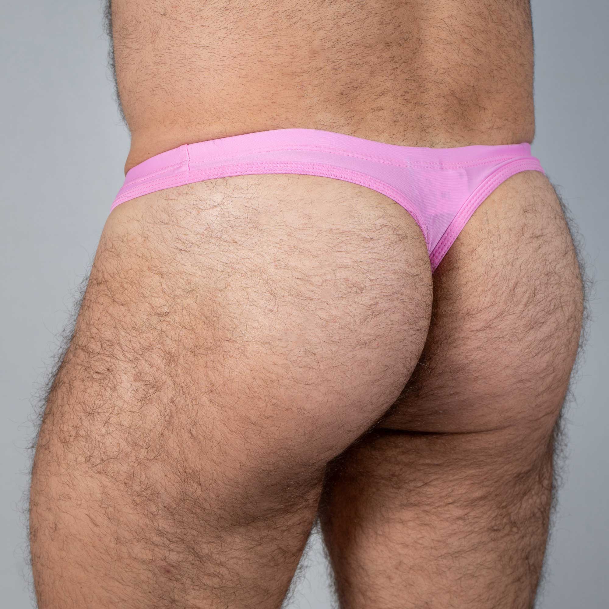 Pink tulio swim thong made of sheer fabric showcasing the front solid design for swimwear use