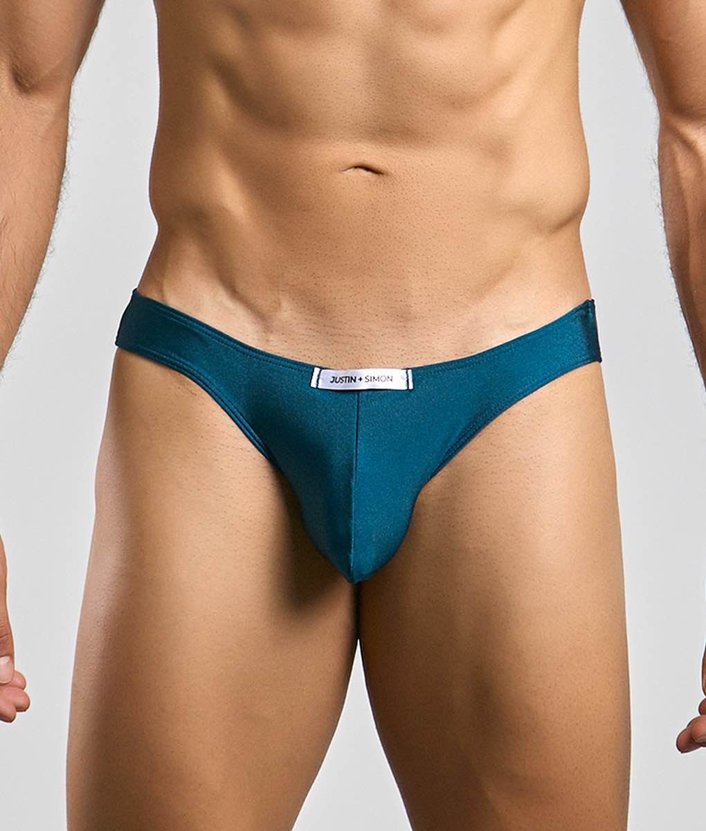 Teal form-fitting briefs with sleek smooth fabric and a white justin + simon label at the waistband classic mens bikini