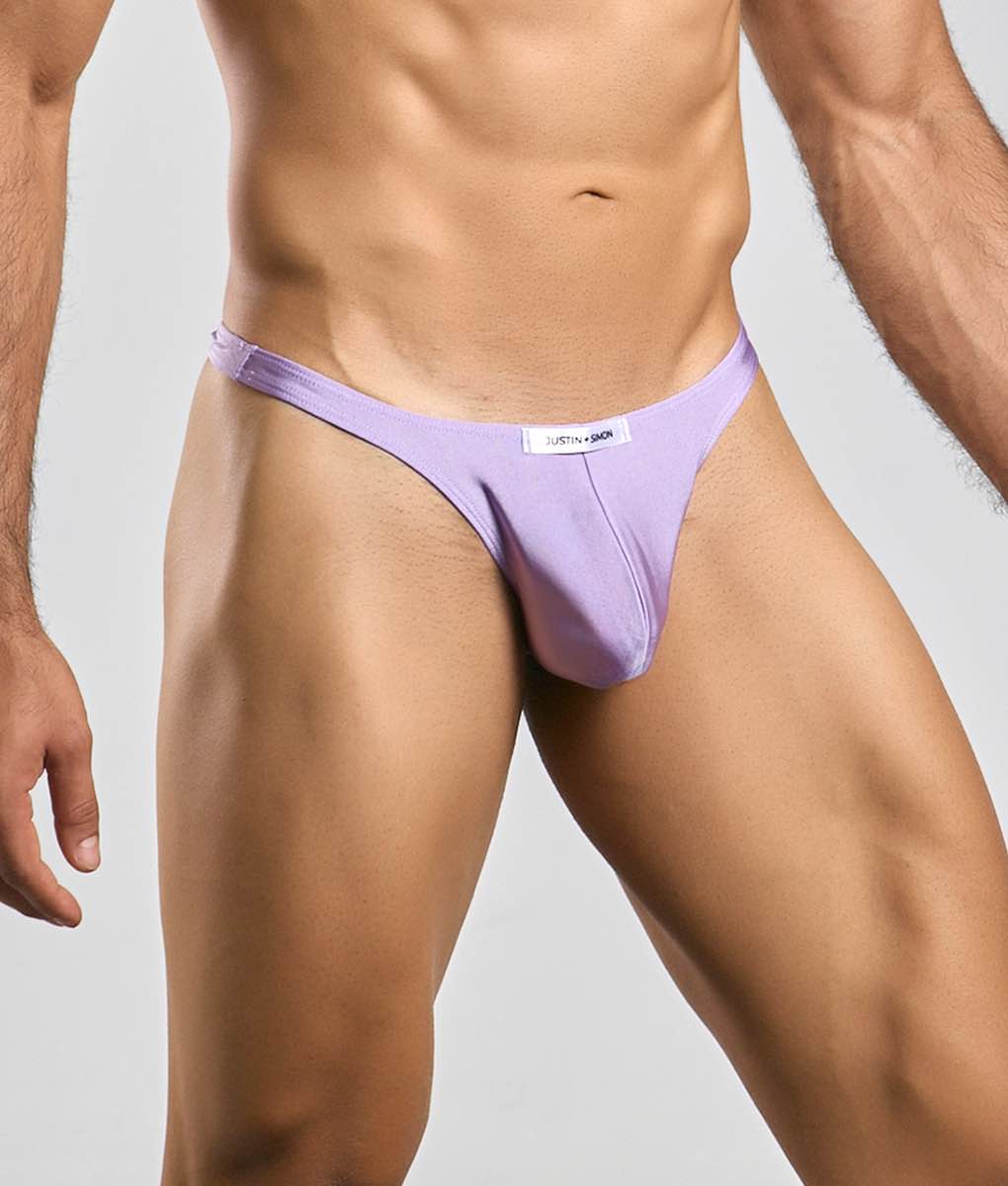 A lavender-colored form-fitting thong made of smooth fabric with a small white label on the waistband from Justin + Simon classic tanga