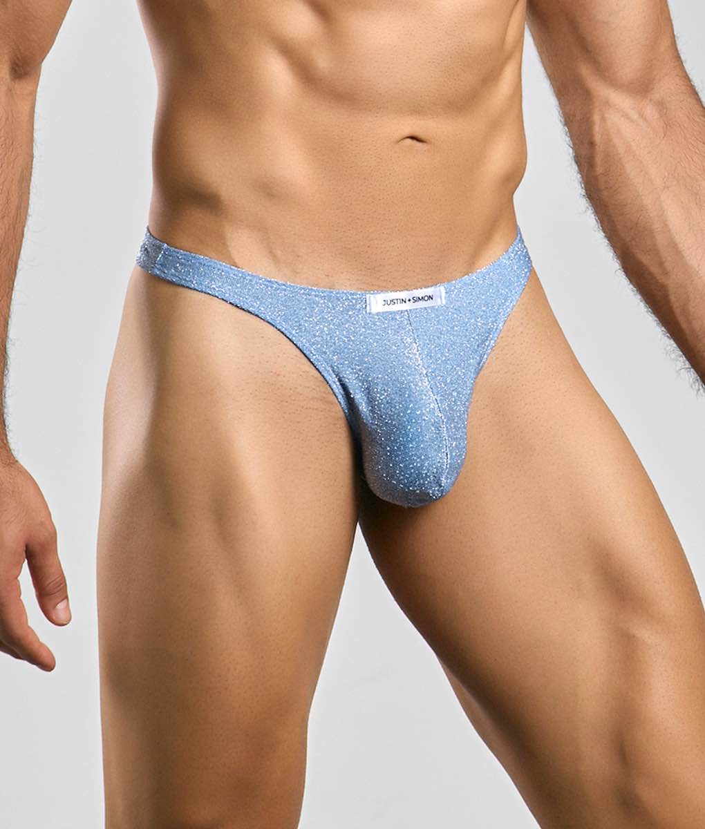 Light blue glittery classic tanga thong with white justin + simon brand tag showing front side