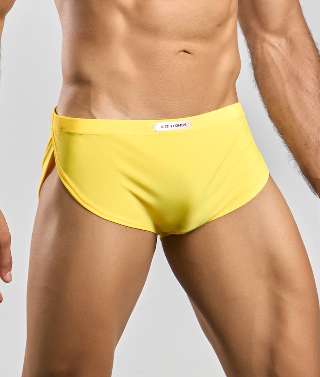 Bright yellow justin simon running short swim trunks with a sleek form fitting design for active use