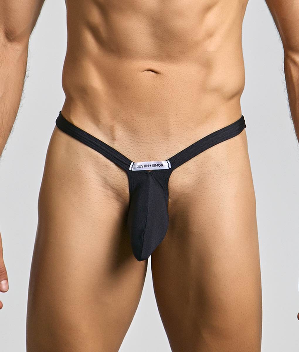 Black justin simon bulge thong with sleek form-fitting design and white brand label at center front