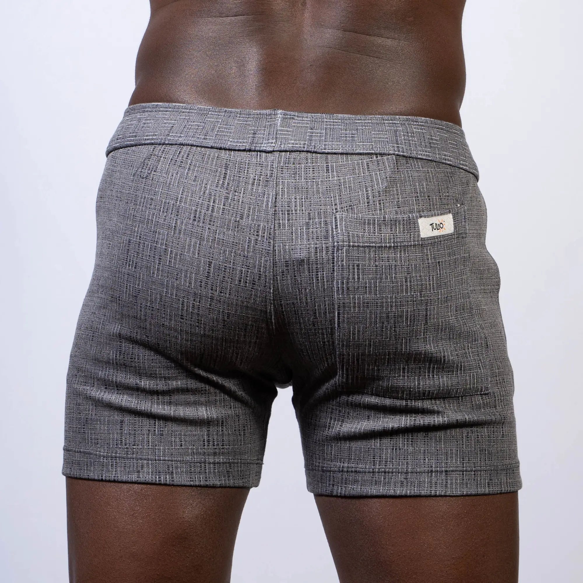 Abstract linen texture gray shorts with subtle herringbone pattern and white brand tag on back waistband shown from back side