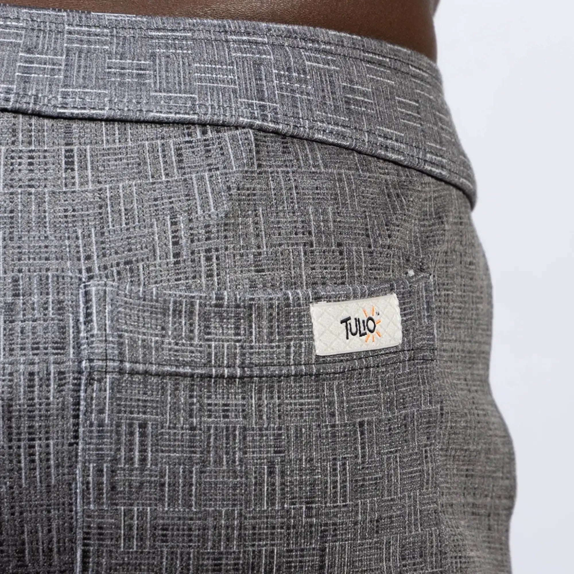 Gray woven linen texture shorts with subtle geometric pattern and tulio brand label on the back pocket visible