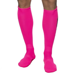 Bright pink ribbed athletic knee-high socks with subtle black branding for vibrant sportswear by Addicted Neon Socks